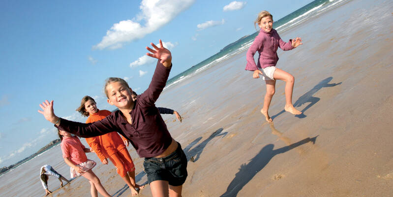 Enfants qui courent sur la plage à marée basse